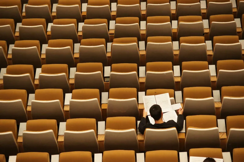 A top down photograph of a man studying inside a college classroom.
